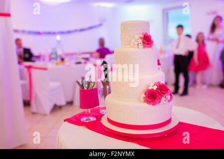 Ein Multi Level weiße Hochzeitstorte auf einen Tisch gelegt Stockfoto