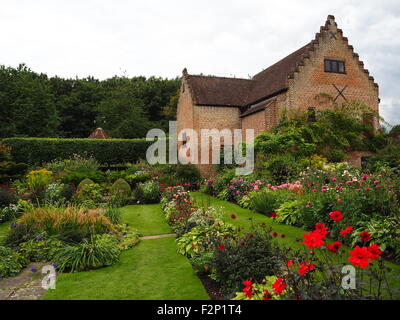 Blick auf den versunkenen Garten im Chenies Manor im Spätsommer zeigt Grass Pfade, rote und rosa Dahlien und grüne Grenze Landschaft. Stockfoto