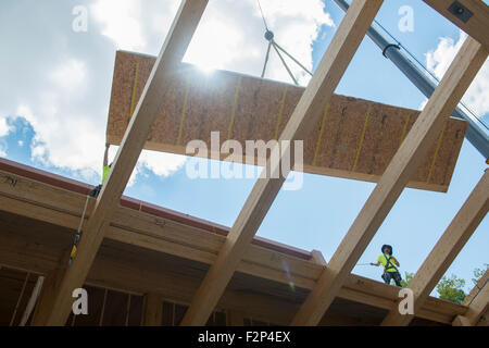 Bauarbeiter installieren Dachplatten auf Leed Platin Common Ground High School Gebäude. Stockfoto