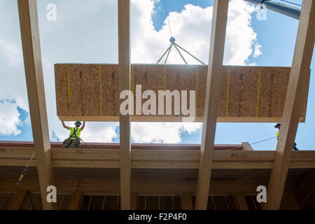 Bauarbeiter installieren Dachplatten auf Leed Platin Common Ground High School Gebäude. Stockfoto