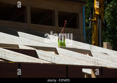 Tischler verwendet Kautschuk Schlitten, um Dachsparren in Leed Platin Common Ground High School Gebäude zu installieren. Stockfoto