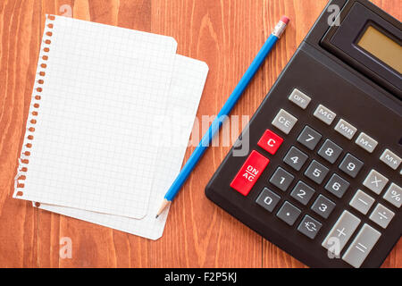 Blatt Papier und Taschenrechner auf hölzernen Hintergrund Stockfoto