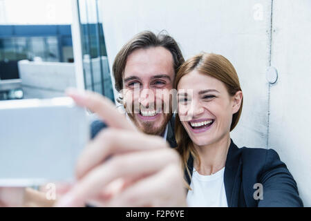 Porträt von zwei Lachen Geschäftsleute nehmen ein Selbstporträt mit smartphone Stockfoto