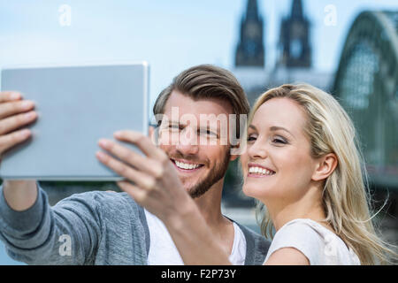 Deutschland, Köln, Porträt von lächelnden jungen Paar ein Selbstporträt mit digital-Tablette nehmen Stockfoto