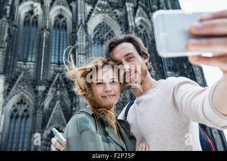 Deutschland, Köln, Porträt des jungen Paares unter ein Selfie vor Kölner Dom Stockfoto