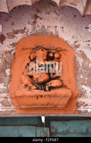 orange rot Lord Ganesha unter Bogen oben Haus Haupttor mit alten Erbe grüne Holztor und Rosa Wand Stockfoto