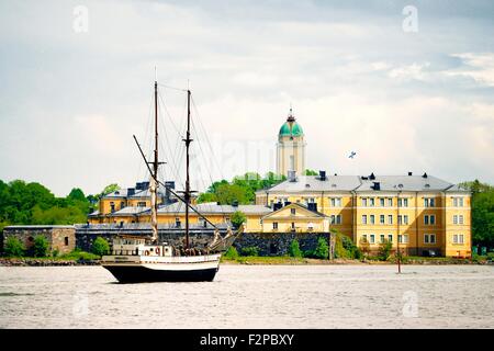 Helsinki, Finnland. Befestigungen und Marineakademie auf Pikku Mustasaari. Teil der Festung Suomenlinna. Kirche-Leuchtturm hinter Stockfoto