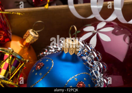 Bunte Weihnachtskugeln und Dekoration in der Holzkiste. Nahaufnahme Schuss Stockfoto