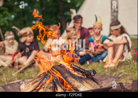 Deutschland, Sachsen, Indianer und Cowboy Party, Kinder sitzen am Lagerfeuer Stockfoto