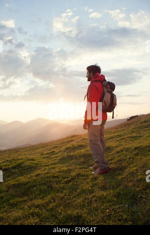 Österreich, Tirol, Unterberghorn, Wanderer stehend in alpiner Landschaft bei Sonnenaufgang Stockfoto