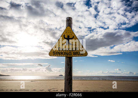 Gefahr Sinking Schlamm - gelbe dreieckige Warnschild am Strand Stockfoto