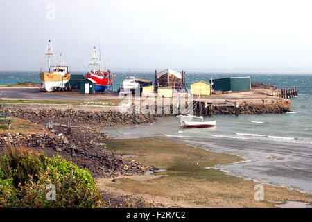 Zwei große und 1 kleines Fischerboot aus dem Wasser in einem Trockendock, warten auf Reparaturen. Kleine Fischerhütte im f/g Stanley, Tasmanien, Australien Stockfoto