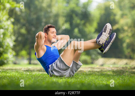 Junge Sportler Sit in einer Wiese an einem schönen sonnigen Tag Stockfoto