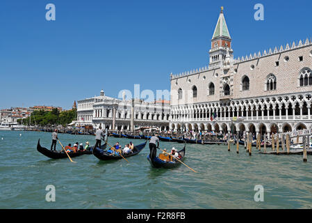 Gondeln mit Touristen und Gondolieri vor Palazzo della Zecca und der Palazzo Ducale, der Dogen-Palast, Venedig, Venezia Stockfoto