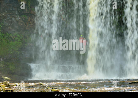 Junges Paar hinter Sgwd yr Eira Wasserfall; Afon Hepste Fluss Brecon Beacons, Wales Stockfoto