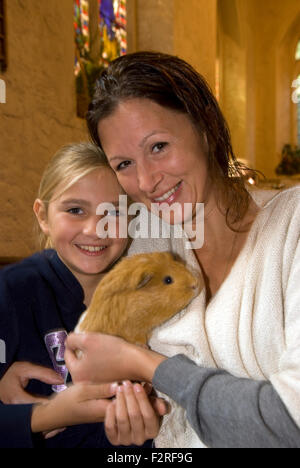Mutter und 10 jährige Tochter und ihre Meerschweinchen an der Kirche, in die Gemeinde eingeladen wurden, ihre Haustiere mitbringen... Stockfoto
