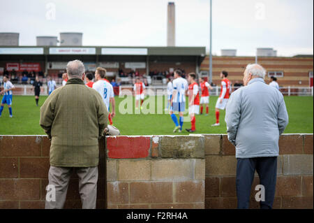 Fans, die gerade ein Spiel auf Didcot Stadt Non - League Football Ground mit Didcot Kraftwerk im Hintergrund Stockfoto