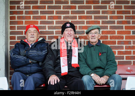 3 Fußball-Fans tragen Mützen und Schals, die gerade ein Spiel Stockfoto