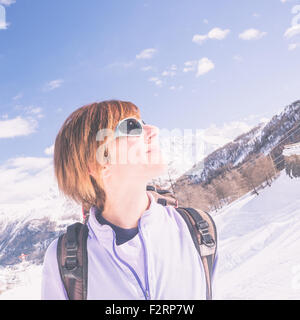 Erwachsene weibliche Skifahrer mit Rucksack und eine Sonnenbrille mit Glück an einem sonnigen Tag im Skigebiet von La Thuile, Aosta-Tal. C Stockfoto