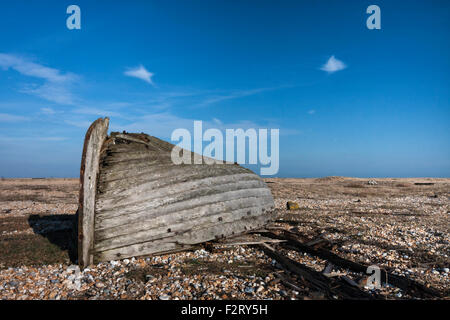 Alten umgedrehten Wrack eines Fischerbootes am Strand bei Dungeness, Kent, England, UK Stockfoto