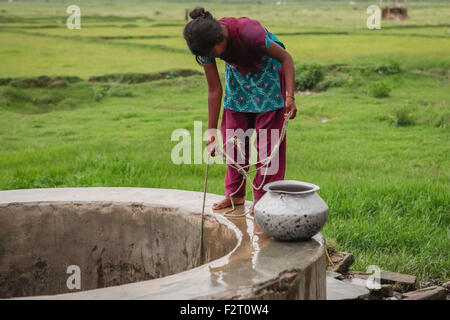 Eine Frau nimmt Wasser aus einem kommunalen Brunnen im ländlichen Teil von Gaya in Bihar, Indien. Stockfoto