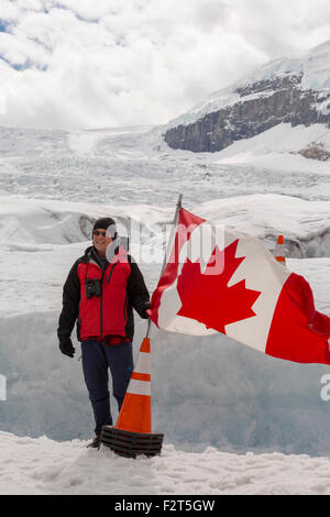 Touristischen posiert mit der kanadischen Flagge am Athabasca Gletscher in den Rocky Mountains, Alberta, Kanada, Nordamerika. Stockfoto