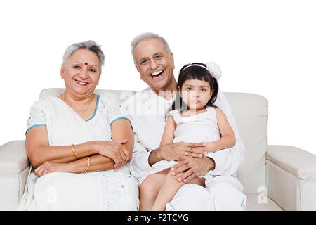 3 indische Großeltern und Enkeltochter sitzen sofa Stockfoto