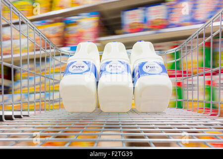 Milch im Einkaufswagen im Supermarkt Tesco. UK Stockfoto