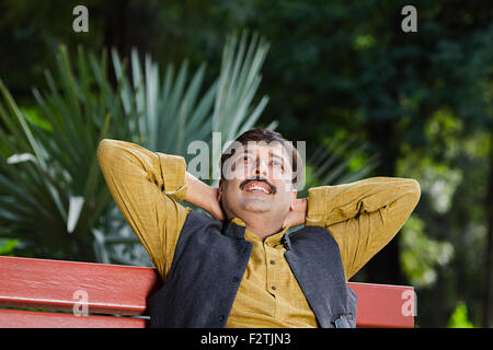 1 indische erwachsenen Mannes Park sitzen Bank Entspannung denken Stockfoto