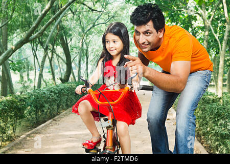 2 indische Vater und Kinder Tochter Park Reiten Fahrrad Finger Gesten Stockfoto