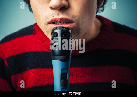 Ein junger Mann in ein Mikrofon sprechen hautnah Stockfoto