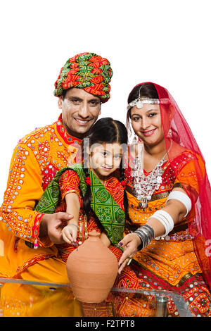 3 indische Rajasthani Dorfbewohner Eltern und Tochter Sparschwein sparen Geld Stockfoto
