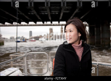 Orientalische Frau von Chinesisch-singapurischer Ethnizität auf Riverbus auf der Themse, London Stockfoto