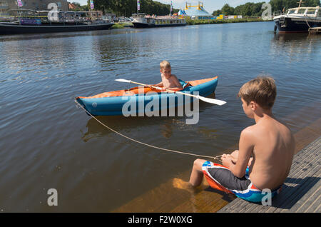 OMMEN, Niederlande - 9. August 2015: Zwei unbekannte Jungs spielen mit ihr Kanu im Fluss Regge. Die Regge-Gegend ist ein beliebtes h Stockfoto