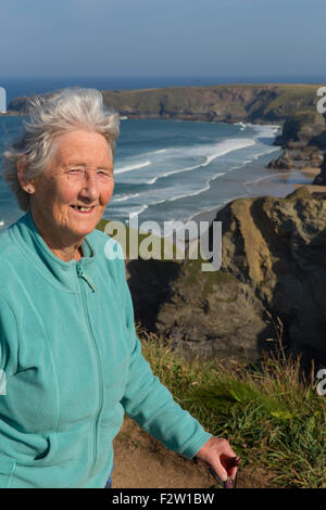Ältere Dame Rentner in den achtziger Jahren mit Haare wehen im Wind und Spazierstock von schönen Küste Szene Stockfoto