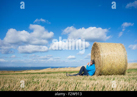 Saltburn am Meer, North Yorkshire, UK. 24. September 2015. UK-Wetter: ein Spaziergänger auf The Cleveland Art National Trail Küsten Fußweg nimmt eine Auszeit auf Klippen hoch über Saltburn an einem hellen und luftigen Donnerstag an der Küste von North Yorkshire. Bildnachweis: Alan Dawson News/Alamy Live-Nachrichten Stockfoto