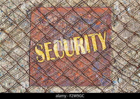 Security Text geschrieben in goldener Farbe unter einem gebrochenen Drahtzaun Stockfoto