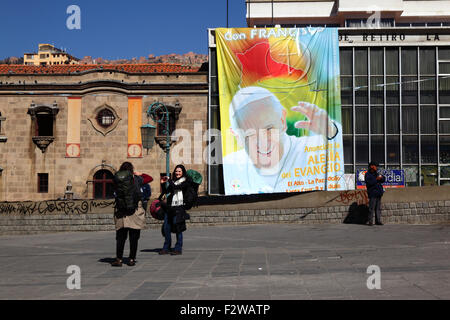 Touristen posieren für Fotos vor einem Banner der Papst Francis im Plaza San Francisco, La Paz, Bolivien Stockfoto