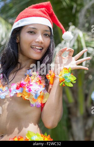 Hawaii Hula-Tänzerin mit Hut von Santa Claus zeigen perfekte Geste Stockfoto