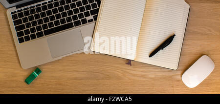 Laptop und öffnete ein Notebook mit einem Stift auf eine Holzoberfläche liegen. Stockfoto