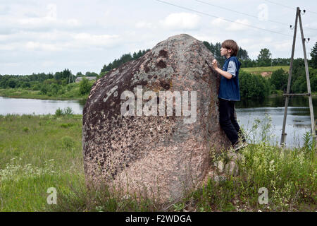 Kinder erkunden große Felsbrocken Miglanu Stein Dubna Flusstal in Latgale Lettland Stockfoto