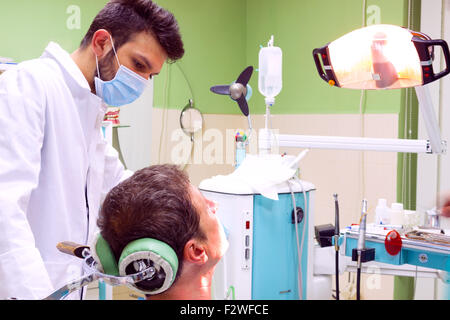 Zahnarzt fixiert die Zähne des Patienten Stockfoto