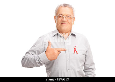 Stolze senior Gentleman in die Kamera schaut und in Richtung einer AIDS-Abzeichen auf seinem Hemd mit dem finger Stockfoto