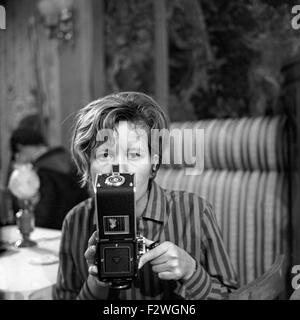 Eine Junge Frau Mit Einer Mittelformatkamera ein Einem Filmset, 1960er Jahre Deutschland. Eine junge Frau mit einer Kamera auf einem Film-Set, Deutschland der 1960er Jahre. Stockfoto