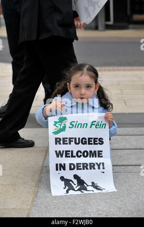 Kleines Mädchen mit Poster bei einer Kundgebung in Londonderry, Nordirland, zur Unterstützung der humanitären Flüchtlingskrise. Stockfoto