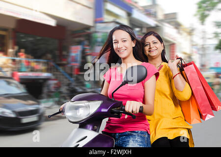 2 indische Mutter und junge Tochter Shopping Scooty Reiten Stockfoto