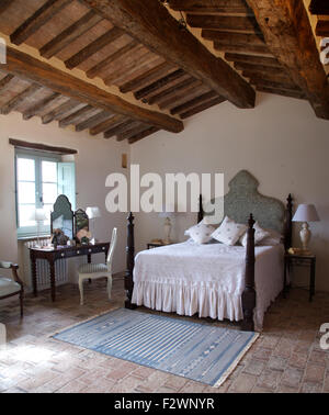 Weißen Bettdecke auf dem Bett mit gedrehten Spindeln in italienischen Land Schlafzimmer mit rustikalen hölzernen Balkendecke Stockfoto