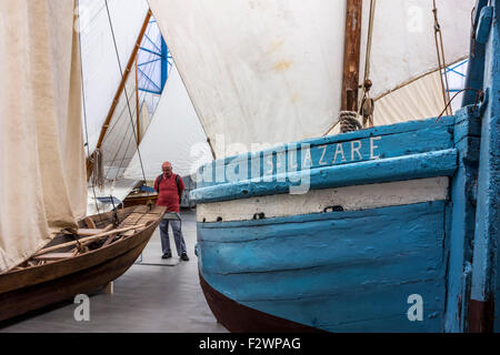 Besucher betrachten alte hölzerne Angelboote/Fischerboote in den Hafen-Musée Bootsmuseum in Douarnenez, Finistère, Bretagne, Frankreich Stockfoto