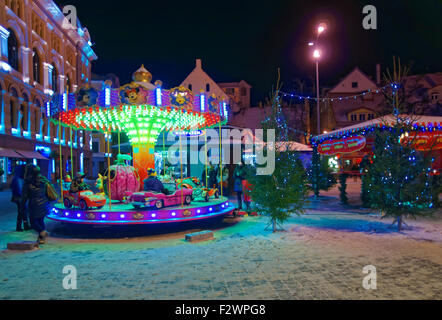 RIGA, Lettland - 28. Dezember 2014: Kleine Kinder reiten ein Karussell auf dem traditionellen Weihnachtsmarkt in der Altstadt Stockfoto