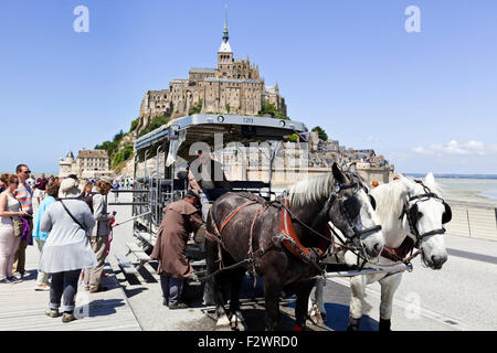 Eine Pferdekutsche, die Touristen zum und vom Mont Saint Michel, Normandie, Frankreich - Mont St Michel Stockfoto